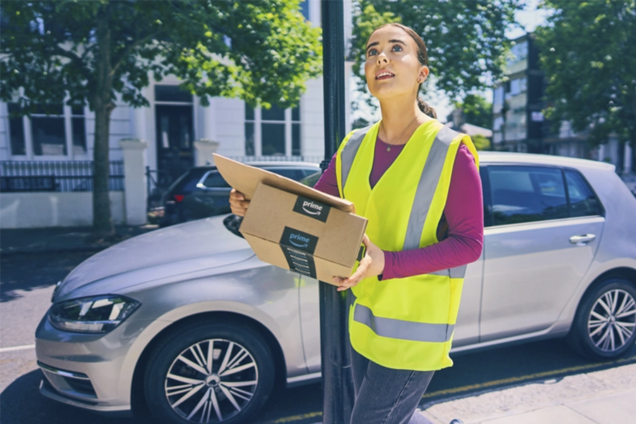 woman in yellow vest holding a package