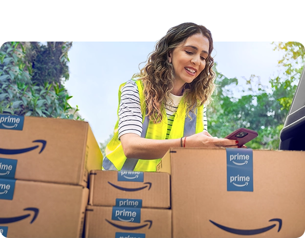 a woman in a yellow safety vest looking at packages in her trunk.